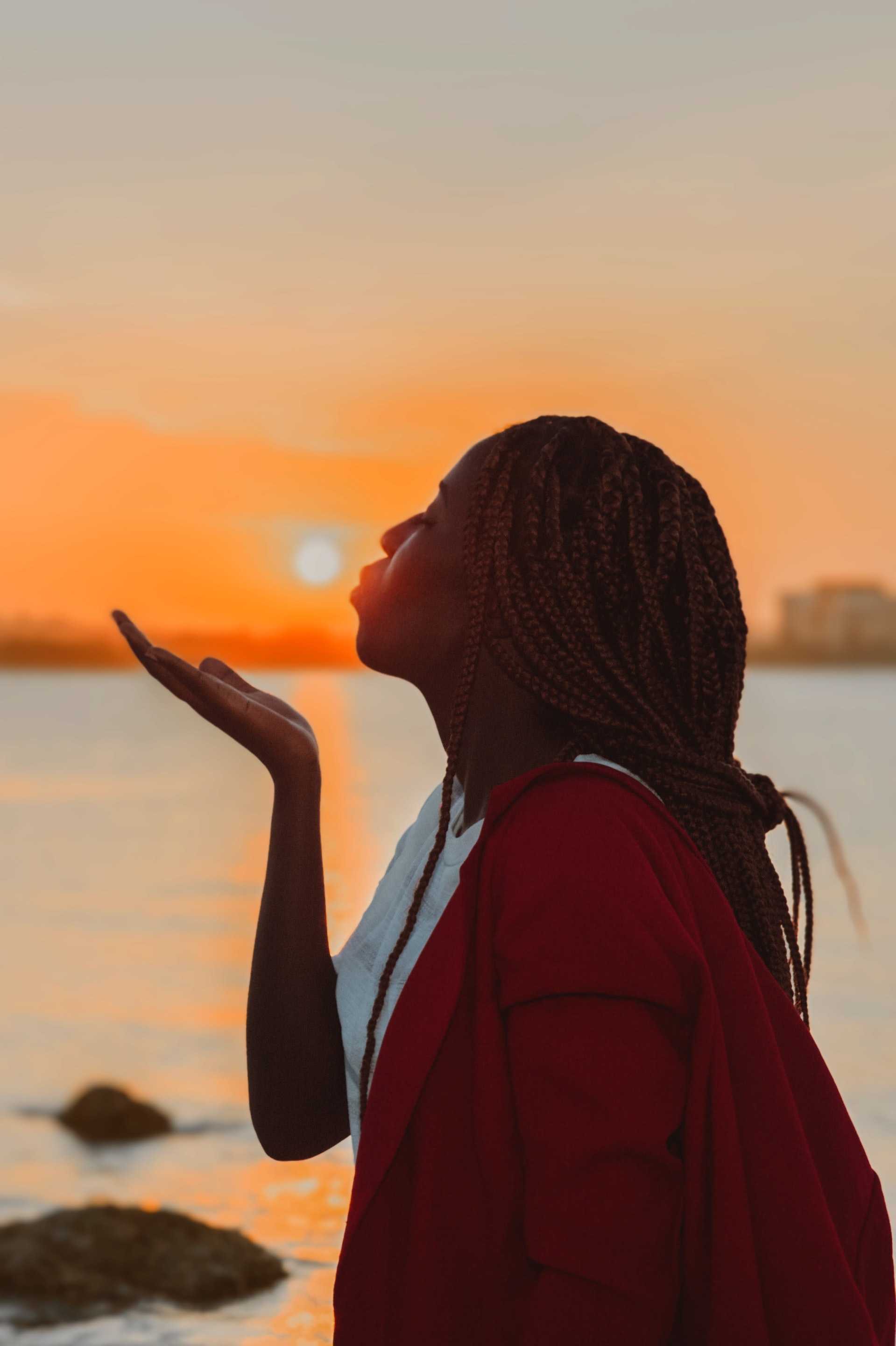 Lady in front of sunset, Dar es Salaam, Tanzania, by Ema Studios via Unsplash